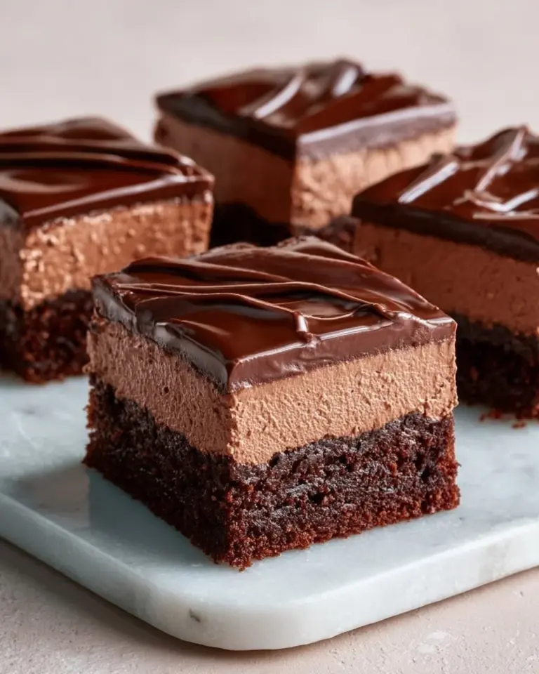 Delicious chocolate mousse brownies topped with a glossy chocolate glaze.