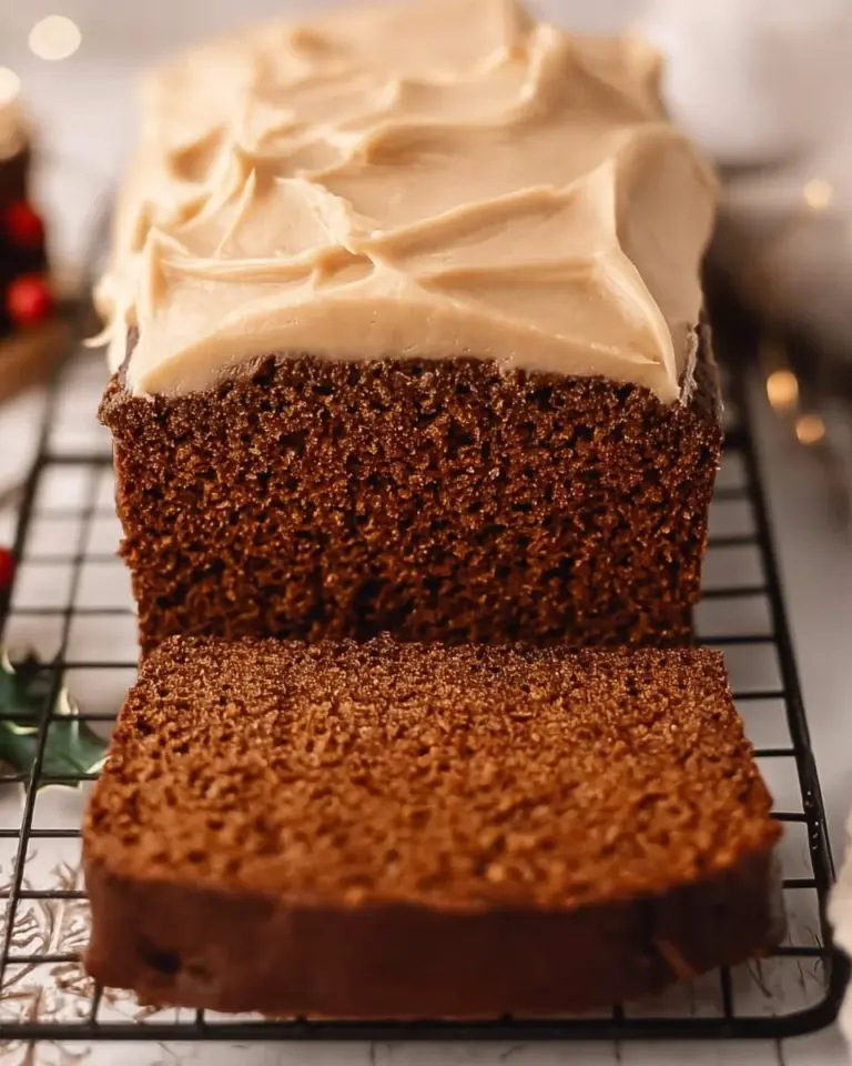 Freshly baked Gingerbread Loaf with spices and icing on a wooden table