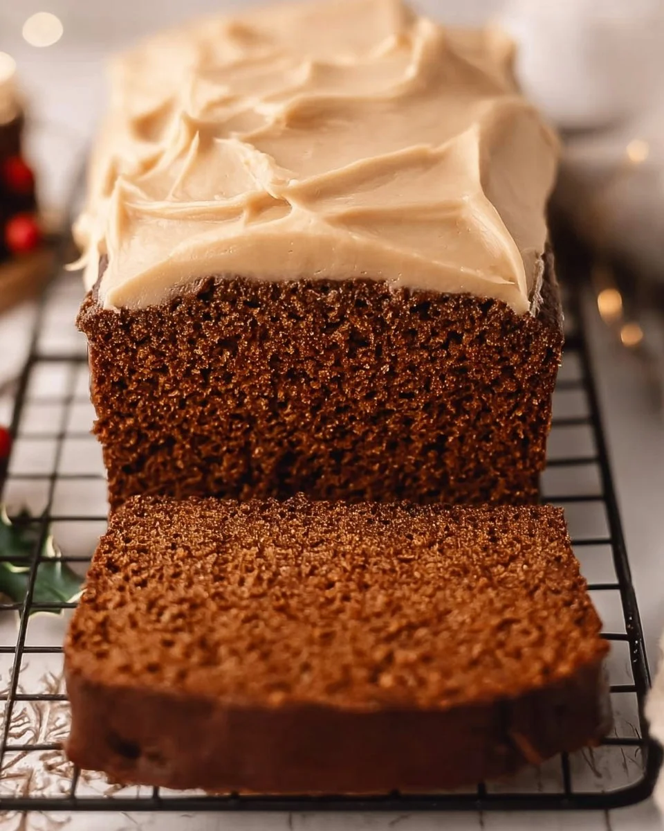 Freshly baked Gingerbread Loaf with spices and icing on a wooden table