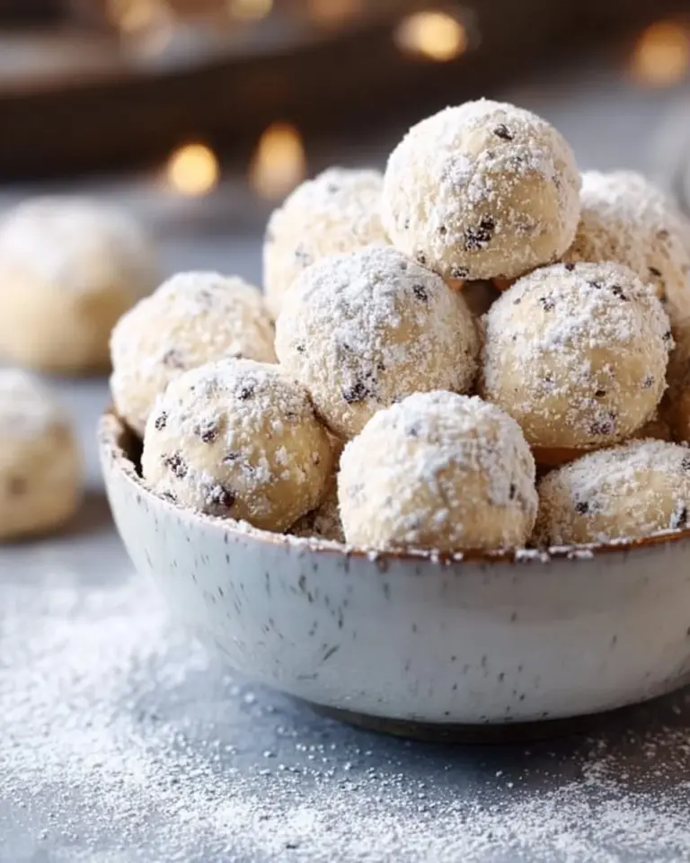 Mini Chip Snowball Cookies dusted with powdered sugar on a plate