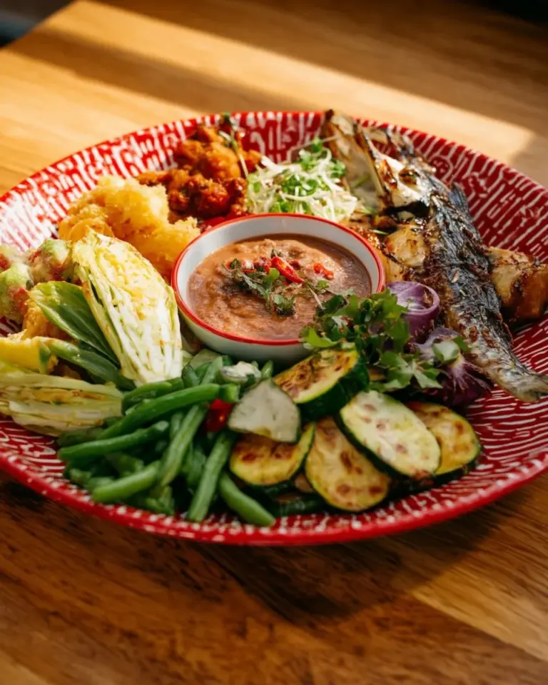 Bowl of Thai shrimp paste dip served with fresh vegetables and herbs