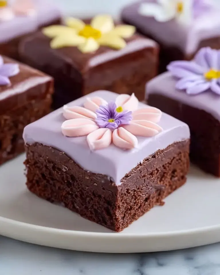 Delicious spring brownies topped with colorful edible flowers and seasonal fruits.